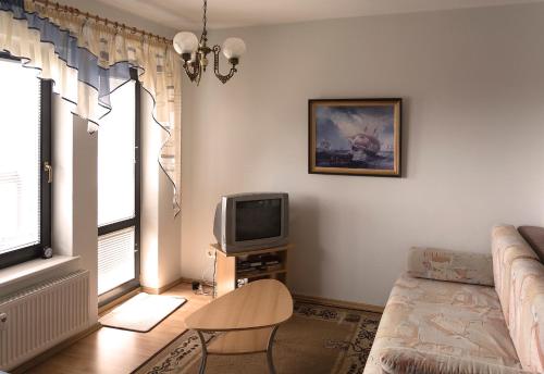 a living room with a couch and a tv at Pärnu Karusselli Beach Apartment in Pärnu