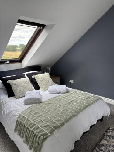 a bedroom with a large bed with a window at The Ducks - Stunning remote Norfolk Appt with Lazy Spa in Mileham
