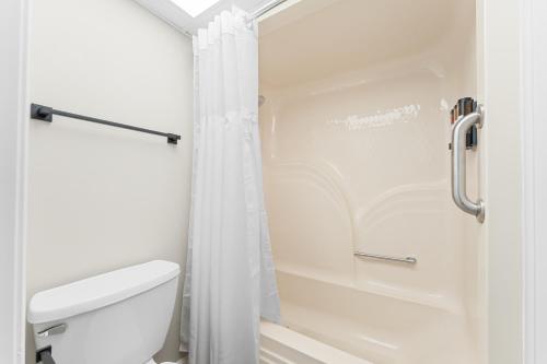 a white bathroom with a toilet and a shower at Branson Falls Lodge in Branson