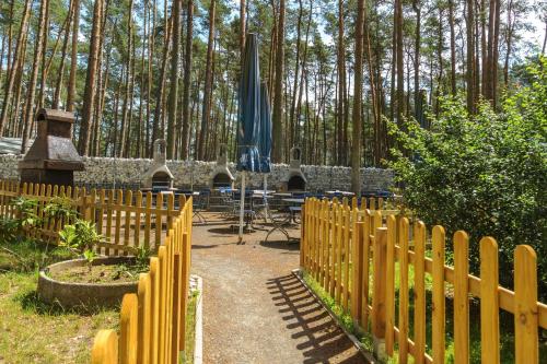 LütowUrlaub im Bungalow mitten im Wald的带桌子和遮阳伞的木栅栏
