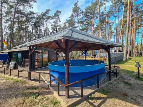 LütowUrlaub im Bungalow mitten im Wald的小屋前方的凉亭,配有蓝色浴缸