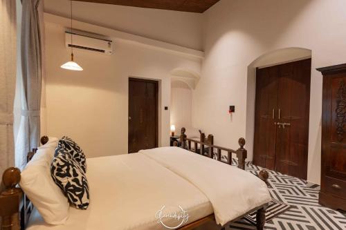 a bedroom with a bed and a wooden door at Villa Serendipity Aldona in Aldona