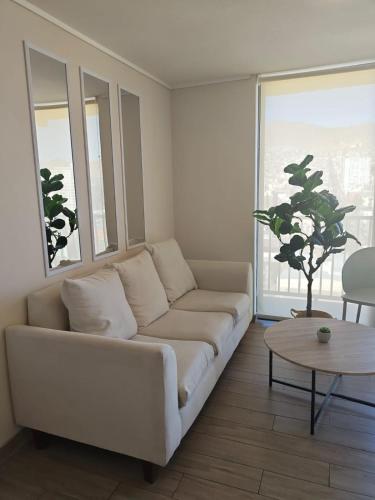 a living room with a white couch and a table at Departamento Central Vip in Antofagasta