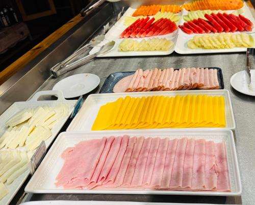 a buffet line with different types of meats and cheeses at Riellis Center Hotel in Botucatu