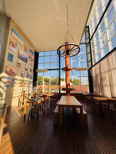 a restaurant with tables and chairs and a large window at Riellis Center Hotel in Botucatu