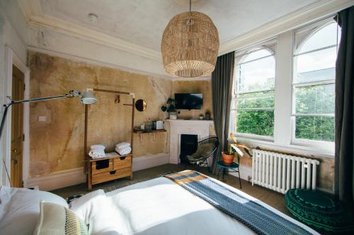 a bedroom with a bed and a chandelier at The Culpeper Bedrooms in London