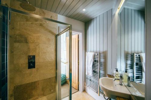 a bathroom with a sink and a shower and a mirror at The Culpeper Bedrooms in London