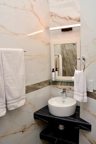 a bathroom with a sink and a mirror and towels at Casa Angel in Morelia