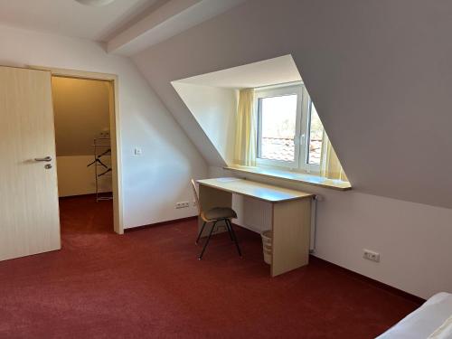 an attic room with a desk and a window at GER-Haus in Waischenfeld