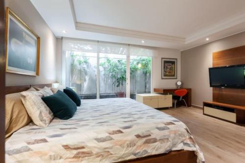 a bedroom with a large bed and a flat screen tv at Mi casa #2 at Polanco's most exclusive area in Mexico City