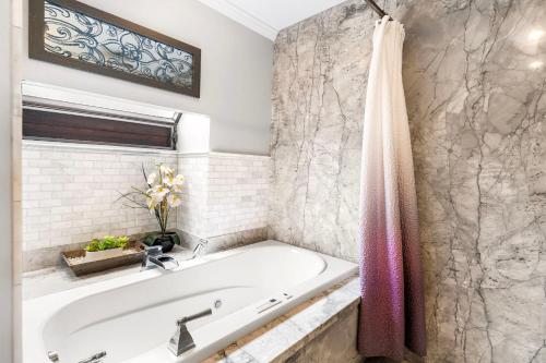 a bath tub in a bathroom with a sink at Mauna Lani Terrace D203 in Waikoloa