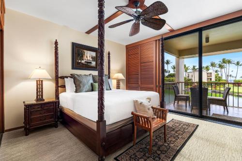 a bedroom with a four poster bed and a balcony at Mauna Lani Terrace D203 in Waikoloa