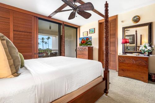 a bedroom with a large bed and a mirror at Mauna Lani Terrace D203 in Waikoloa