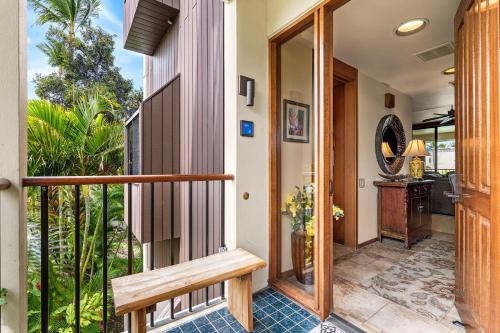a porch with a wooden door and a bench at Mauna Lani Terrace D203 in Waikoloa