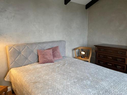 a bedroom with a bed with a pink pillow and a dresser at " Bernies Seeglück" in Penzlin