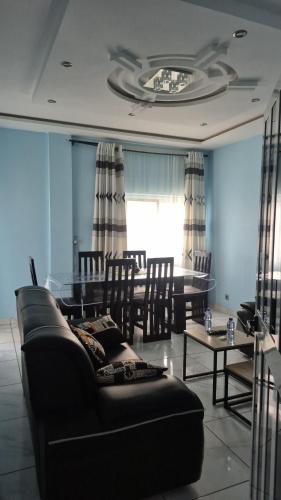 a living room with a black couch and a table at Appartement moderne avec balcon in Lomé