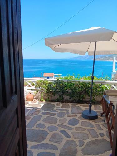 a view of the ocean from a patio with an umbrella at Emmy Rooms in Armenistis