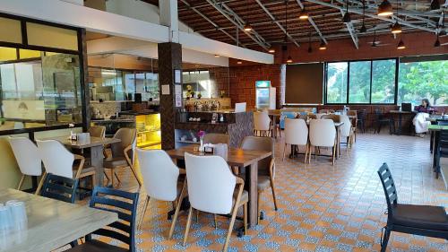 a restaurant with tables and chairs and a bar at HillRock Resort & Villas, Neral-Karjat in Karjat