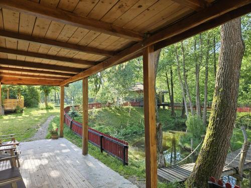 an outside view of a wooden porch with a tree at Parcul Manga 