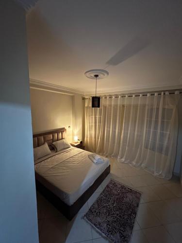a bedroom with a bed and a window with curtains at Appartement Mendoubia in Tangier