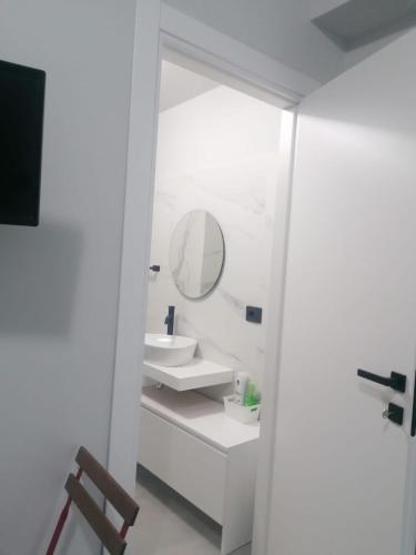 a white bathroom with a sink and a mirror at Casa Tio Pepe in Zingarello