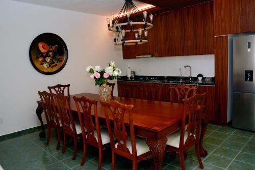 a kitchen with a wooden table with chairs and a refrigerator at Casa Angel in Morelia