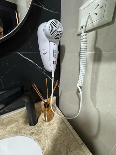 a blow dryer in a bathroom next to a sink at Departamento céntrico Félix de Azara in Puerto Iguazú