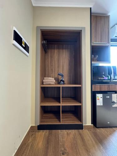 a kitchen with wooden shelves and a refrigerator at Departamento céntrico Félix de Azara in Puerto Iguazú
