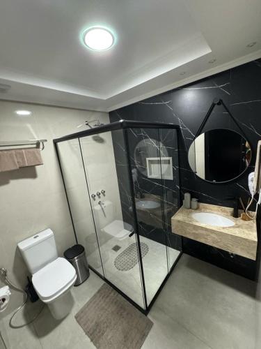a bathroom with a toilet and a tv on the wall at Departamento céntrico Félix de Azara in Puerto Iguazú