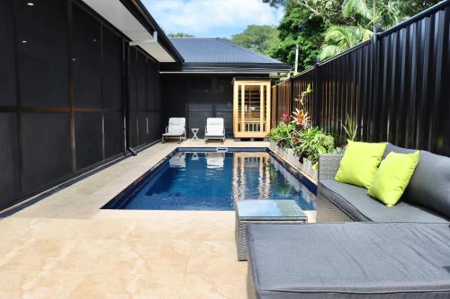 a swimming pool in a backyard with a couch at Alam Kesehatan Wellness retreat in Nimbin