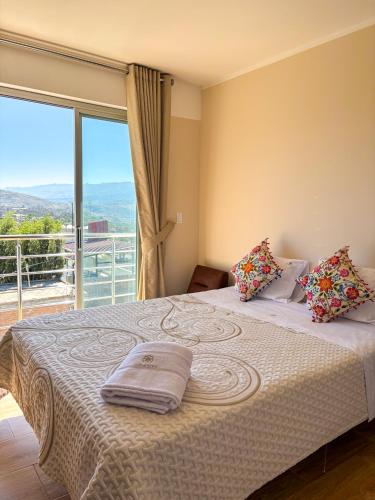 a bedroom with a large bed with a large window at Hotel Club Las Flores Ayacucho in Ayacucho