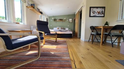 a living room with chairs and a table and a bed at The Drey Inchberry 