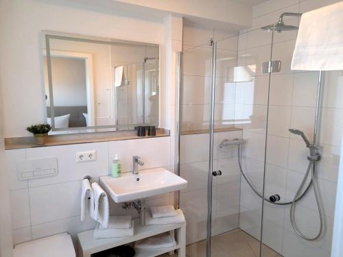 a white bathroom with a sink and a shower at Seestern 02 in Grömitz