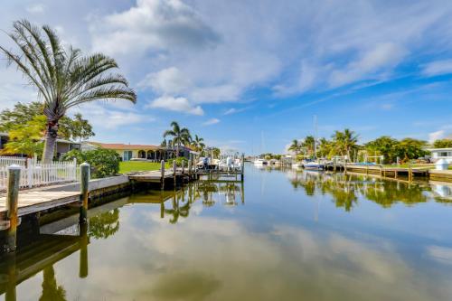 a body of water with a palm tree and houses at Canal-Front Haven Pool, Dock and Lanai in Palmetto in Palmetto
