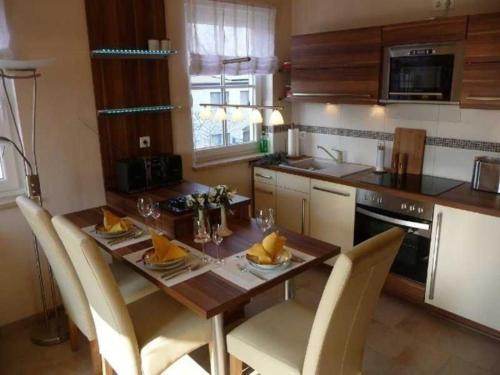 a kitchen with a wooden table with chairs and a tableasteryasteryasteryasteryastery at Ferienwohnung Seeanemone I - GM 69353 in Graal