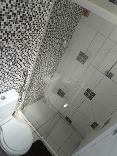 a bathroom with a shower and a white toilet at Casa da isy hospedagem in Natal