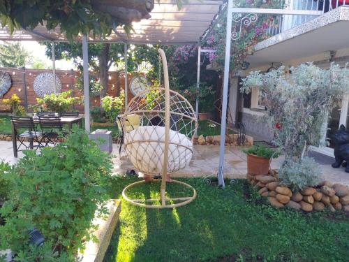 ein Garten mit einer Vogelschaukel im Gras in der Unterkunft Maison en rez-de chaussée près du centre ville d'Arles in Arles