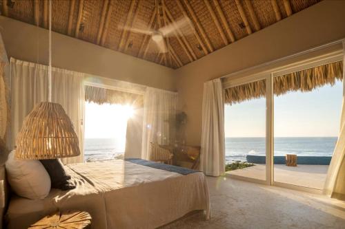 a bedroom with a bed with a view of the ocean at Punta Majahua by PRC Hospitality in La Majahua