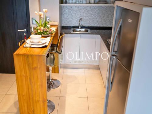 a kitchen with a wooden table and a refrigerator at Suite moderna con vista a la ciudad y al río en Puerto Santa Ana in Guayaquil