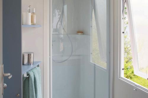 a bathroom with a shower with a glass door at Camping Rouffignac-St-Cernin in Ladeymarie