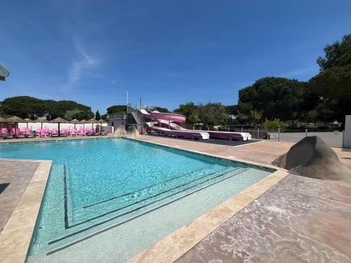 une grande piscine avec un toboggan en arrière-plan dans l'établissement Camping Saint-Nazaire, à Saint-Nazaire
