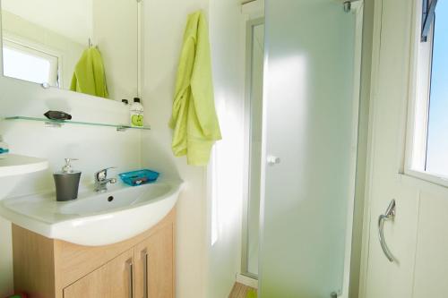 une salle de bain avec un lavabo et une douche dans l'établissement Camping Saint-Nazaire, à Saint-Nazaire