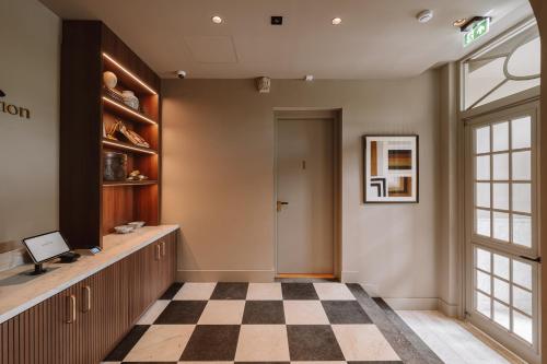 a lobby with a checkered floor and a door at The Saints Hotel in Den Bosch