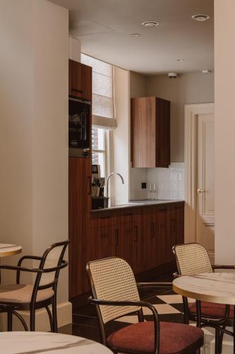 a kitchen and dining room with tables and chairs at The Saints Hotel in Den Bosch