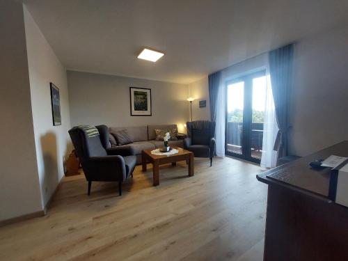 a living room with a couch and chairs and a table at Fewo mit malerischem Bergblick im in Bischofsmais