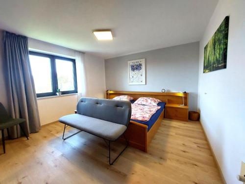 a small bedroom with a bed and a chair at Fewo mit malerischem Bergblick im in Bischofsmais