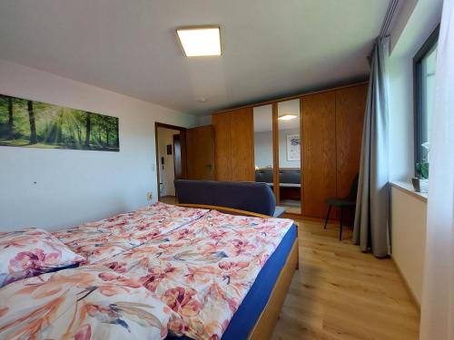 a bedroom with a bed with a floral bedspread at Fewo mit malerischem Bergblick im in Bischofsmais