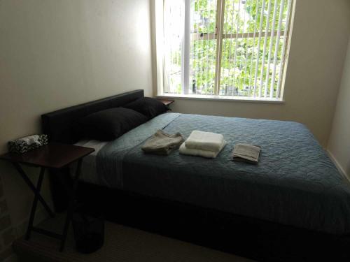 une chambre avec un lit avec deux serviettes dessus dans l'établissement Central Townhouse Richards Street, à Vancouver