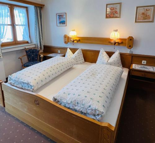 a bedroom with a large bed with two pillows at Gästehaus Kleinbuch in Bad Wiessee