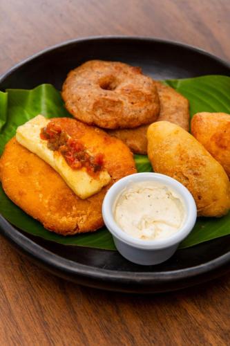 a plate of food with onion rings and dipping sauce at Kanta Sana in Palomino